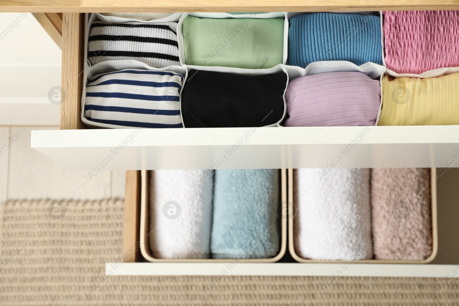 Photo of Chest of drawers with different folded clothes, above view