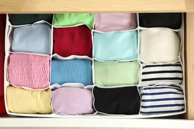 Chest of drawers with different folded clothes, top view