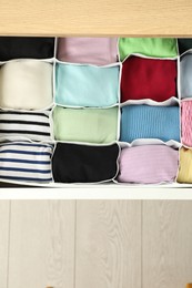 Chest of drawers with different folded clothes, top view