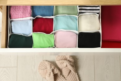 Chest of drawers with different folded clothes indoors, top view