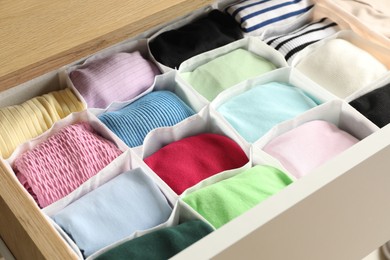 Photo of Chest of drawers with different folded clothes, closeup