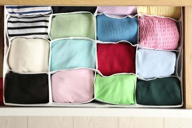 Chest of drawers with different folded clothes, top view