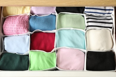 Chest of drawers with different folded clothes, above view