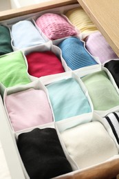 Photo of Chest of drawers with different folded clothes, closeup