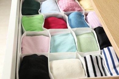 Chest of drawers with different folded clothes, closeup