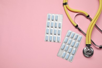 Photo of Antibiotic pills in blisters and stethoscope on pink background, flat lay. Space for text