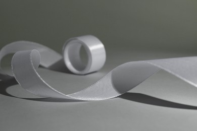 Beautiful white ribbon reel on gray background, closeup