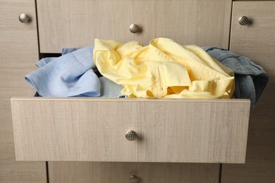 Cluttered chest of drawers, closeup. Clothes in mess