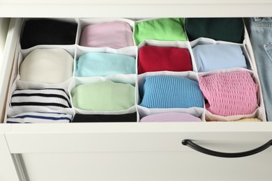 Photo of Chest of drawers with different folded clothes, closeup