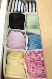 Chest of drawers with different folded clothes, closeup