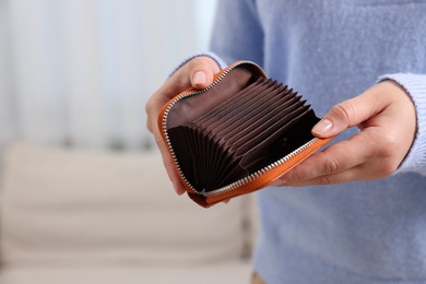 Photo of Woman with empty wallet indoors, closeup view