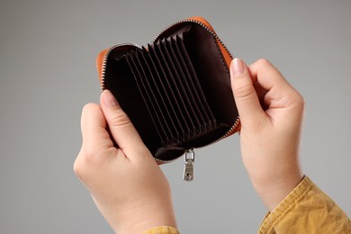 Photo of Woman with empty wallet on grey background, closeup