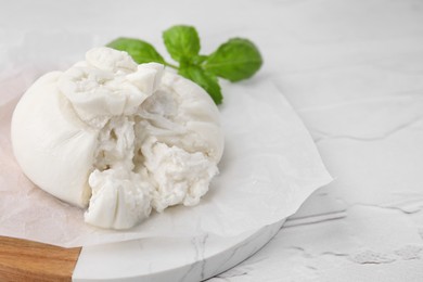 Delicious fresh burrata cheese on white textured table, space for text