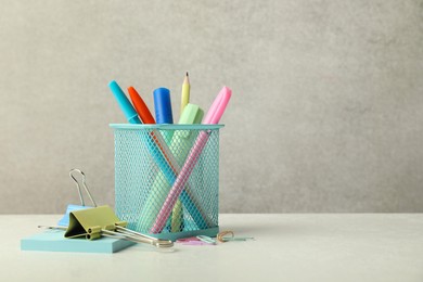 Holder and other different stationery on white table, space for text