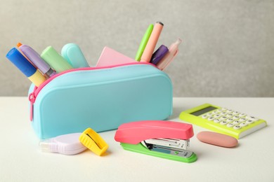 Photo of Stapler, pencil case and other different stationery on white table