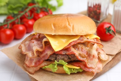 Photo of Delicious burger with bacon, patty and cheese on table, closeup