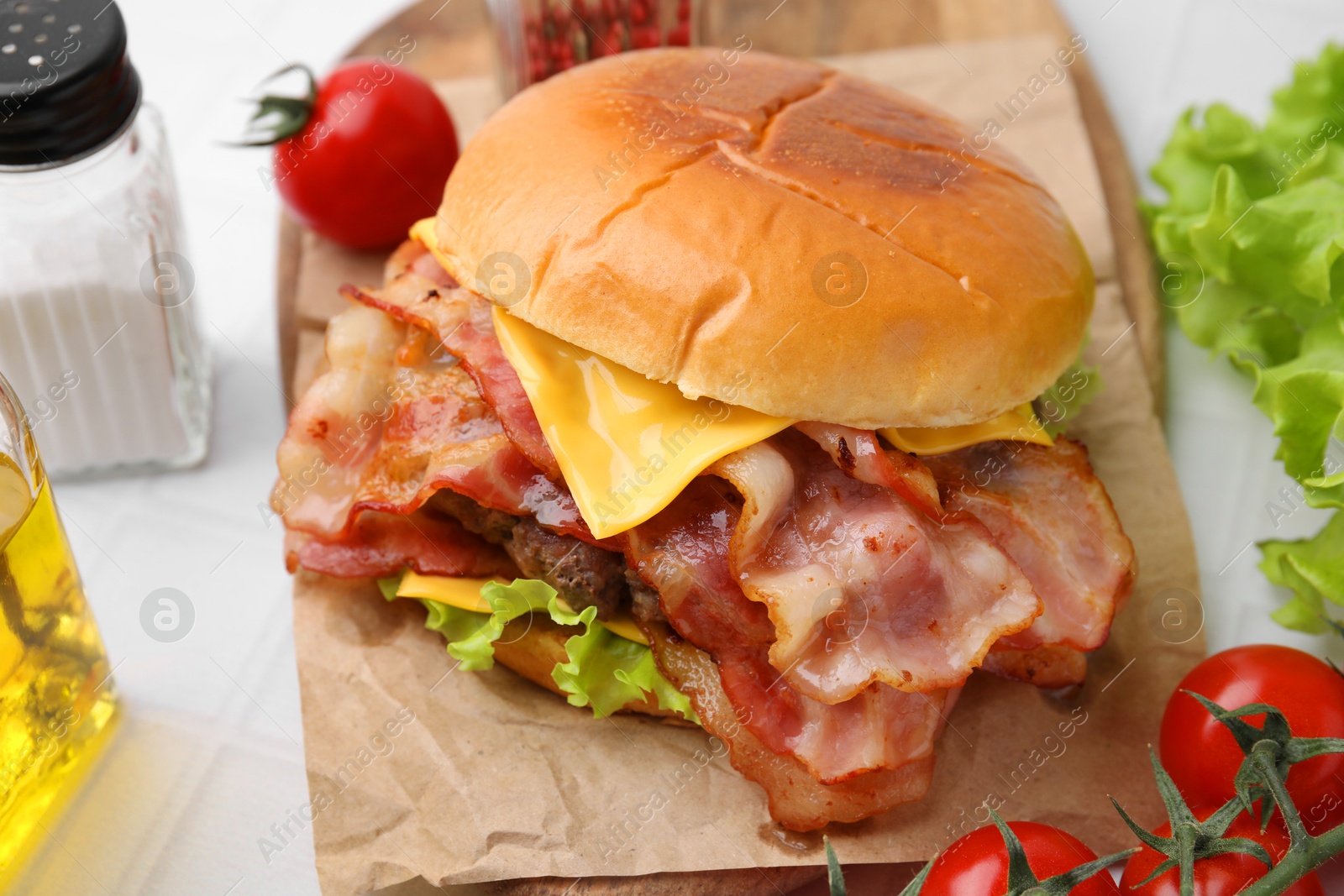 Photo of Delicious burger with bacon served on white table