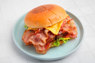 Photo of Delicious burger with bacon, patty and cheese on white tiled table