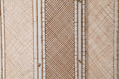 Photo of Beautiful rattan folding screen near wall indoors