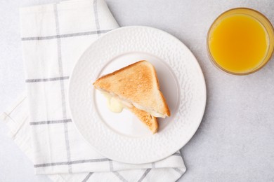 Photo of Pieces of toasted bread with melted cheese and juice on light table, top view