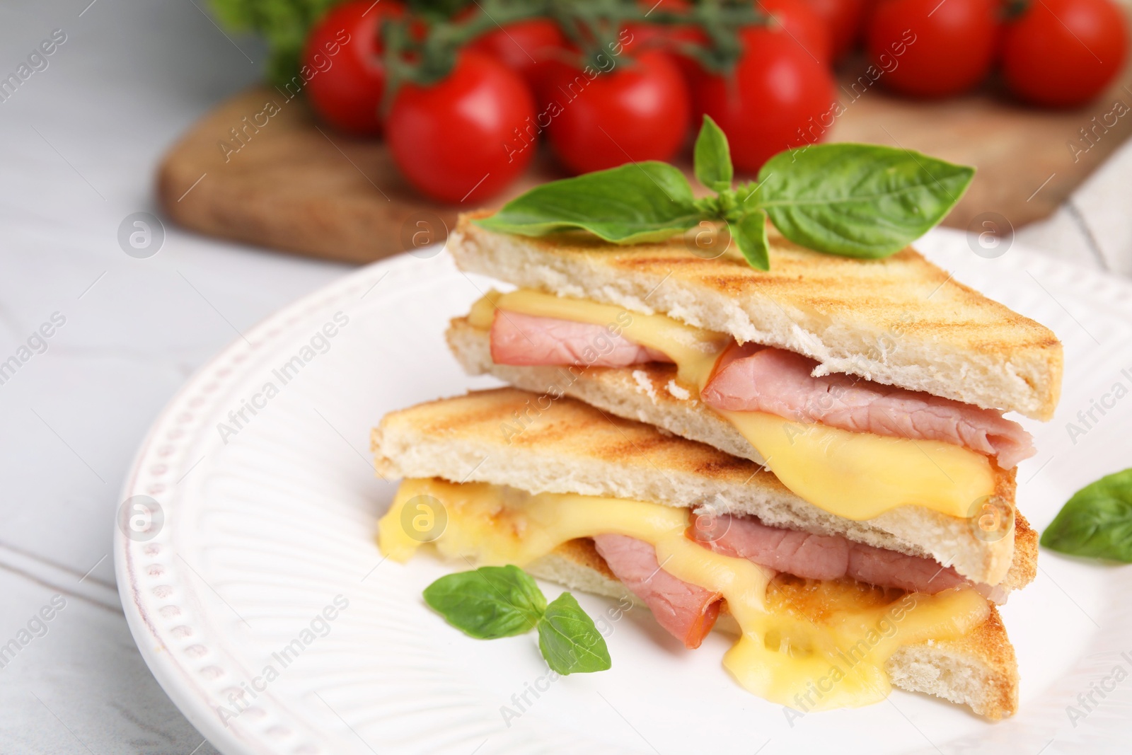 Photo of Pieces of toasted bread with melted cheese, ham and basil on table, closeup