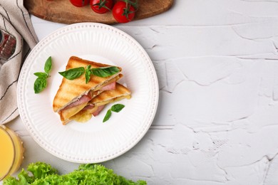 Photo of Pieces of toasted bread with melted cheese, ham and basil on white table, top view. Space for text