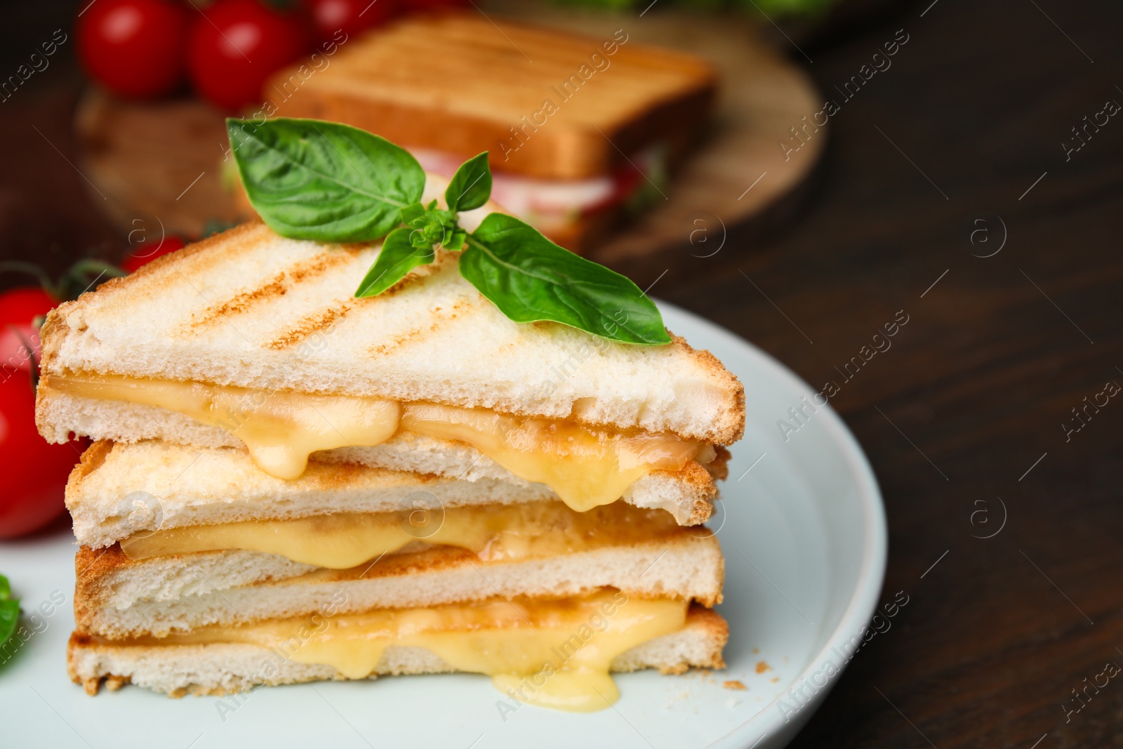 Photo of Pieces of toasted bread with melted cheese and basil on wooden table