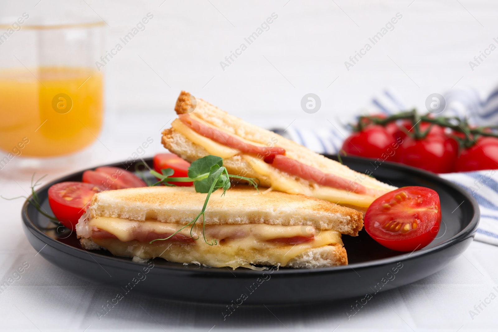 Photo of Pieces of toasted bread with melted cheese, ham and tomatoes on white table