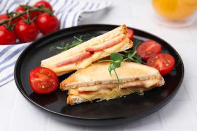 Photo of Pieces of toasted bread with melted cheese, ham and tomatoes on white tiled table