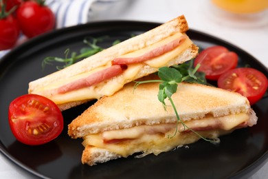 Pieces of toasted bread with melted cheese, ham and tomatoes on table, closeup