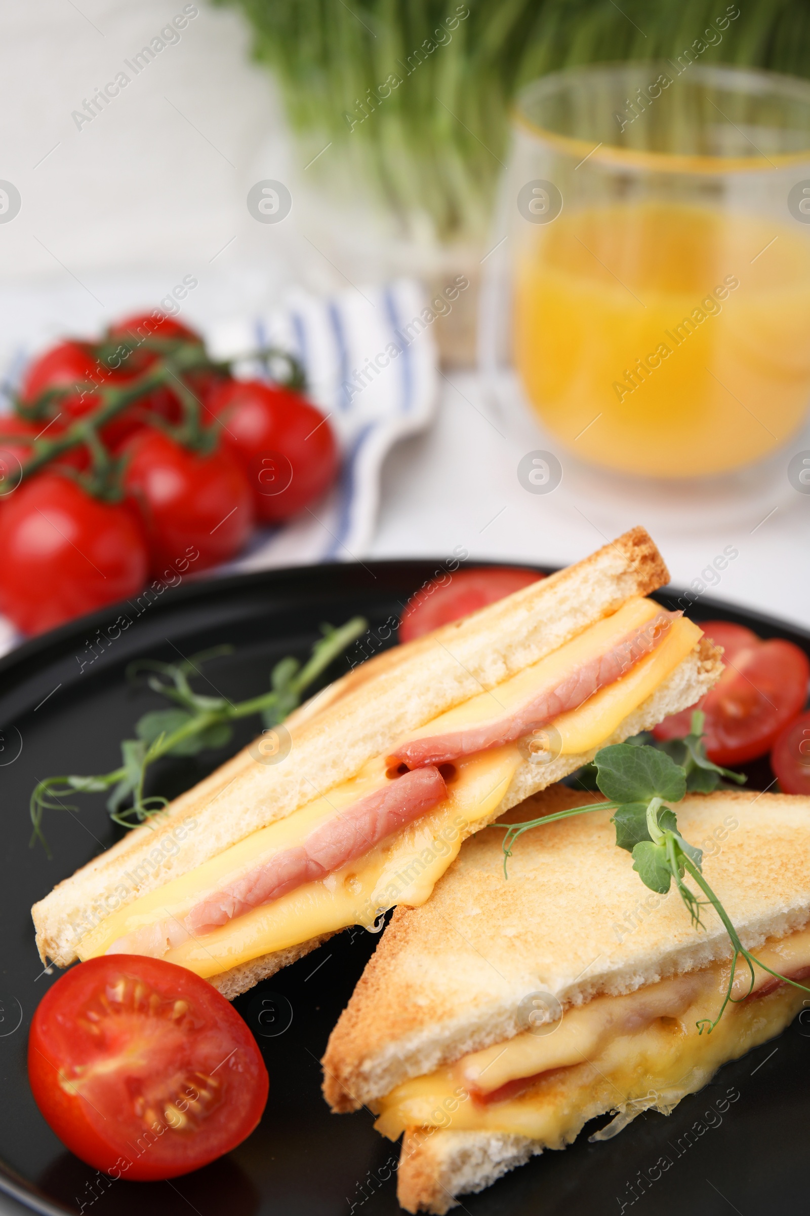 Photo of Pieces of toasted bread with melted cheese, ham and tomatoes on table