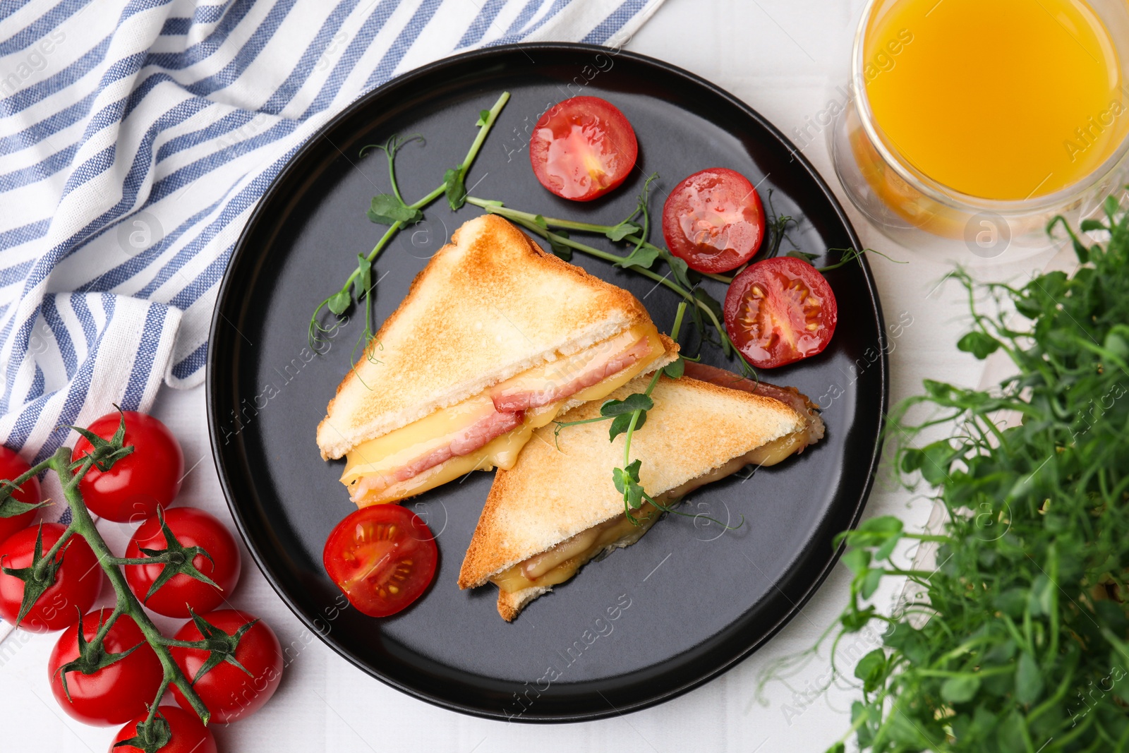 Photo of Pieces of toasted bread with melted cheese, ham, tomatoes and juice on white table, top view