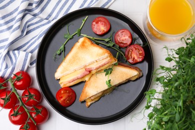 Pieces of toasted bread with melted cheese, ham, tomatoes and juice on white table, top view