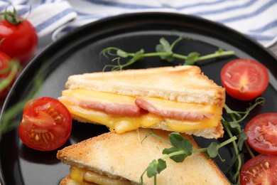 Photo of Pieces of toasted bread with melted cheese, ham and tomatoes on table, closeup