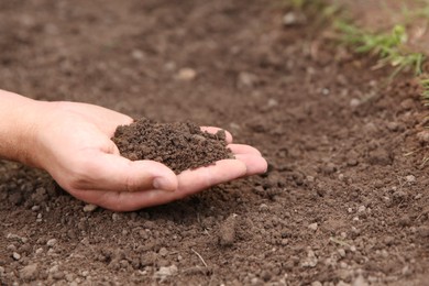 Photo of Woman holding pile of soil outdoors, closeup. Space for text