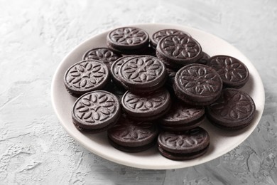 Many tasty sandwich cookies on light grey table