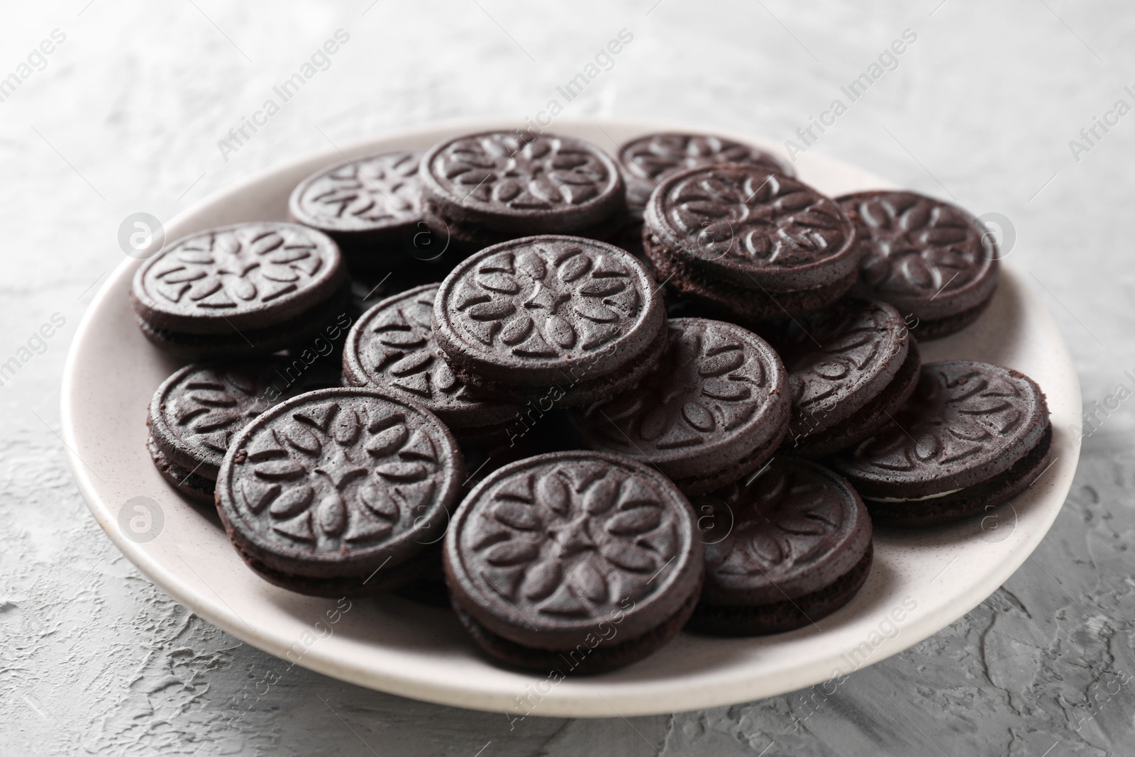 Photo of Many tasty sandwich cookies on light grey table