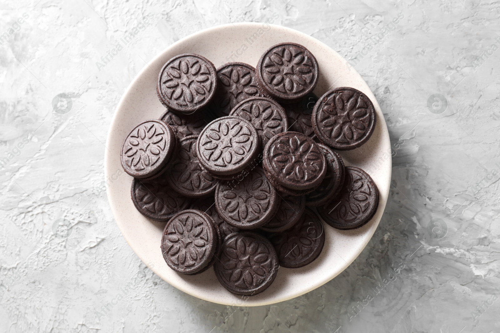 Photo of Many tasty sandwich cookies on light grey table, top view