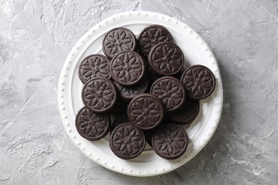 Many tasty sandwich cookies on light grey table, top view