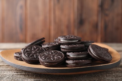 Many tasty sandwich cookies on wooden table