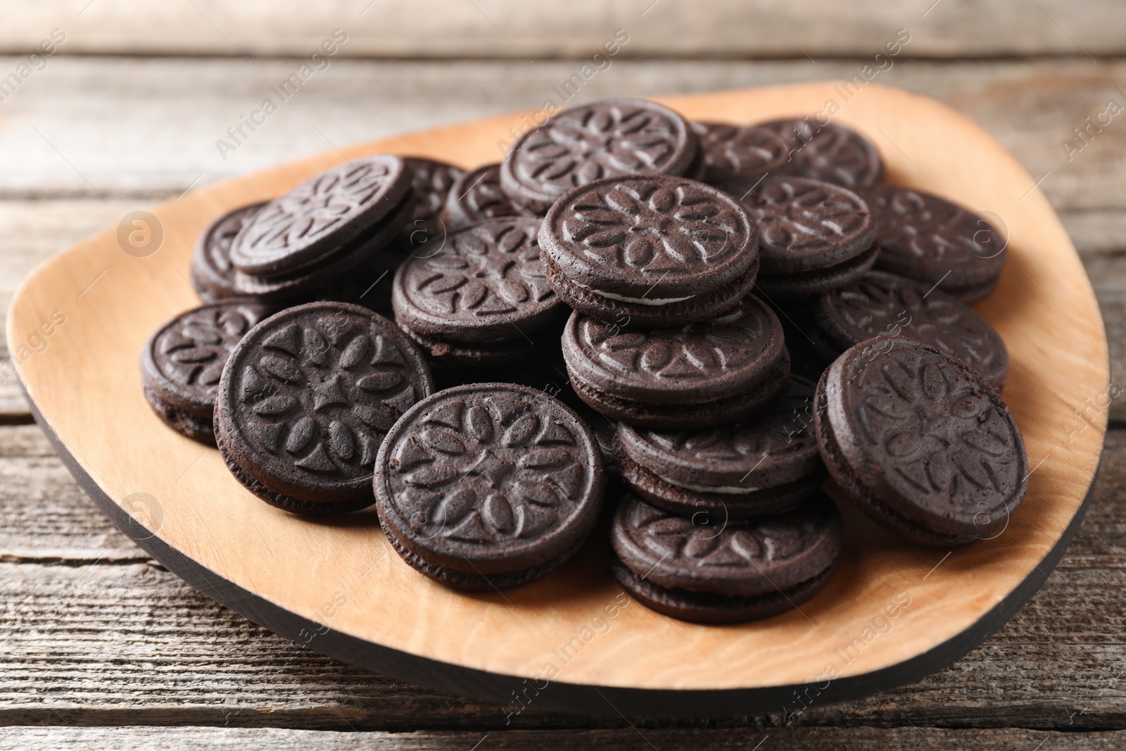 Photo of Many tasty sandwich cookies on wooden table