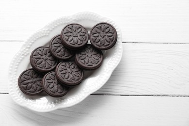 Photo of Many tasty sandwich cookies on white wooden table, top view. Space for text