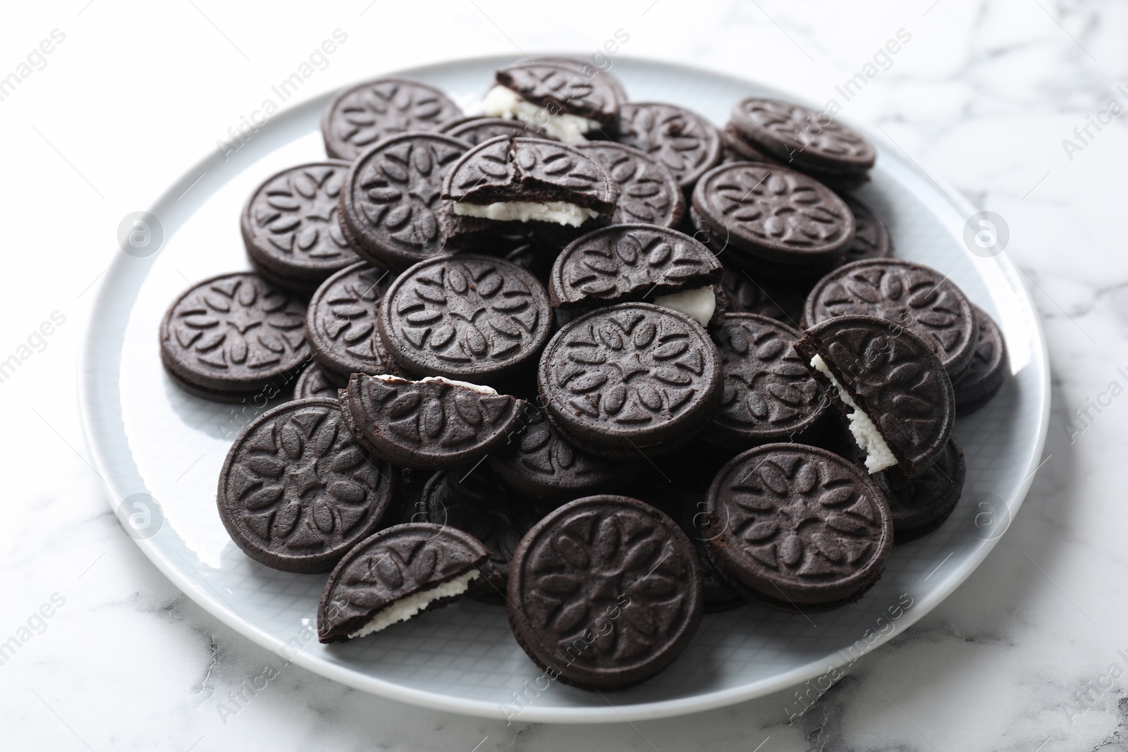 Photo of Tasty sandwich cookies on white marble table