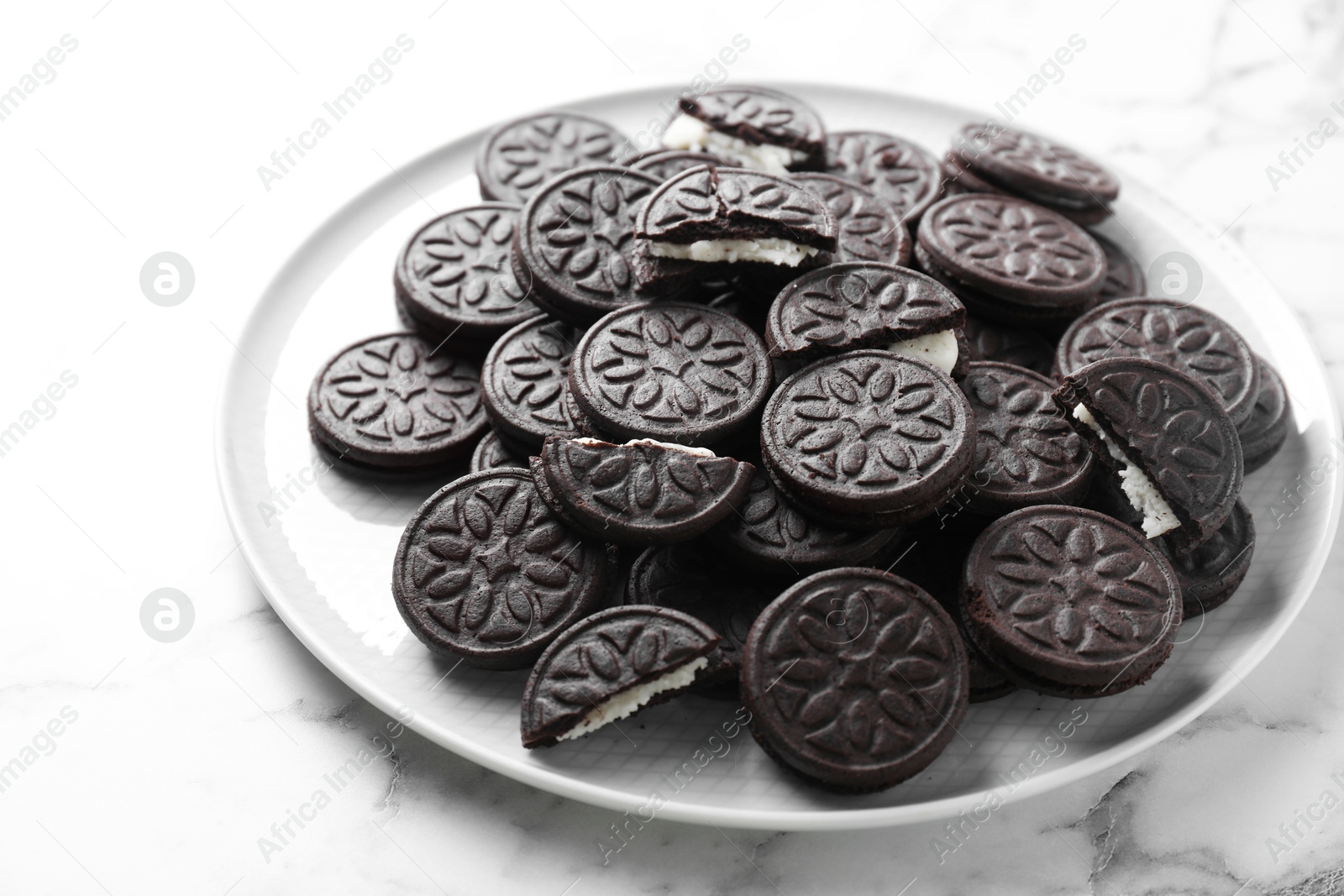 Photo of Tasty sandwich cookies on white marble table