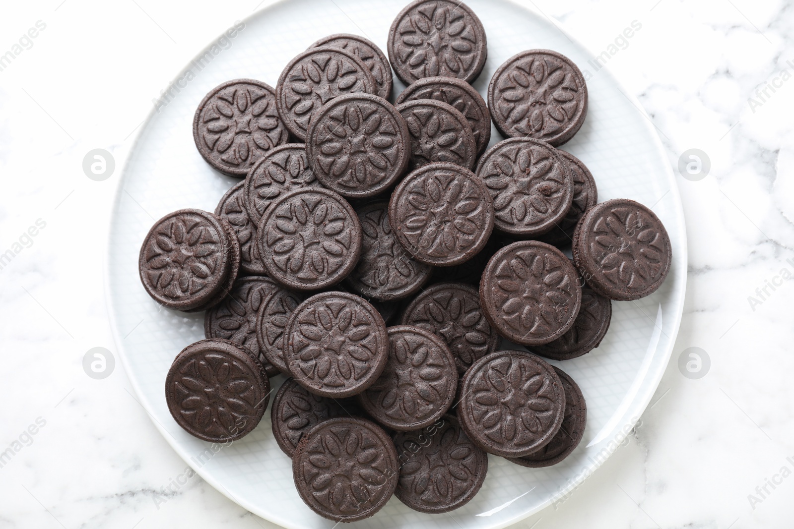 Photo of Tasty sandwich cookies on white marble table, top view