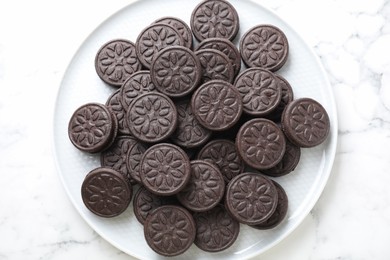 Photo of Tasty sandwich cookies on white marble table, top view