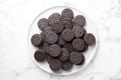 Photo of Tasty sandwich cookies on white marble table, top view