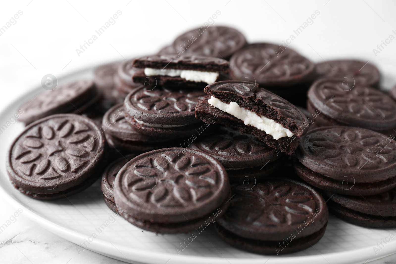 Photo of Tasty sandwich cookies on white marble table, closeup