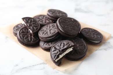 Photo of Tasty sandwich cookies on white marble table