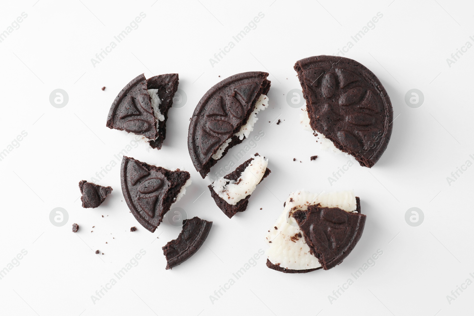 Photo of Broken tasty sandwich cookies on white background, flat lay